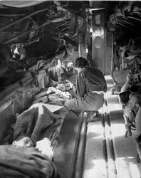 Miss Mary Smith della Carolina del Sud che cura i pazienti durante il volo verso il Nord Africa, c.1943-45, da una collezione di 650 fotografie compilate dall